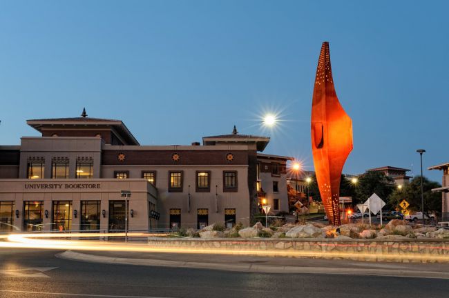 UT El Paso commons area in the evening with the giant pick axe with orange lighting on it 
